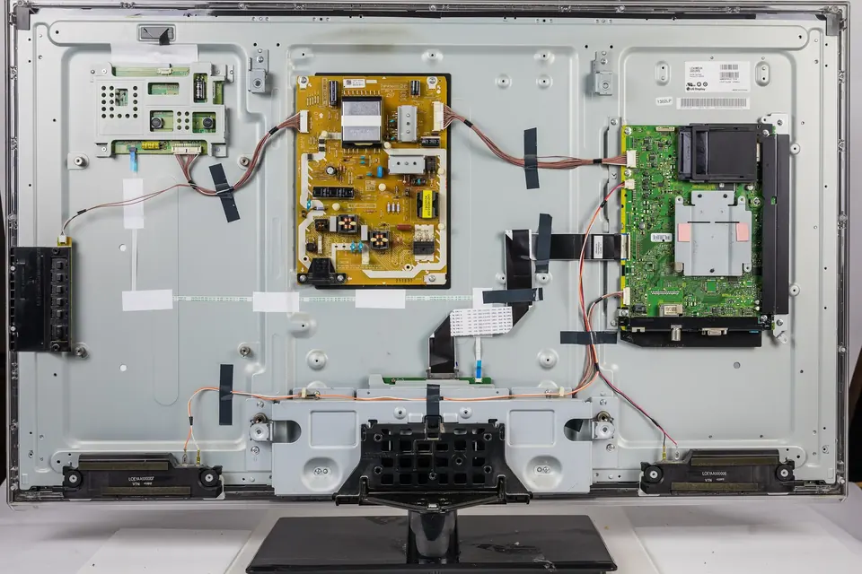 The back of a 42-inch LED-backlit LCD television with its rear panel removed, showing the power supply board, the main board and their cables on the metal chassis