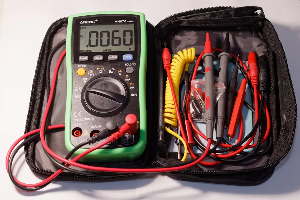A digital multimeter with its test leads in an open zipped carrying case